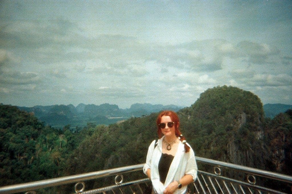 Chloe travelling, standing above a jungle valley